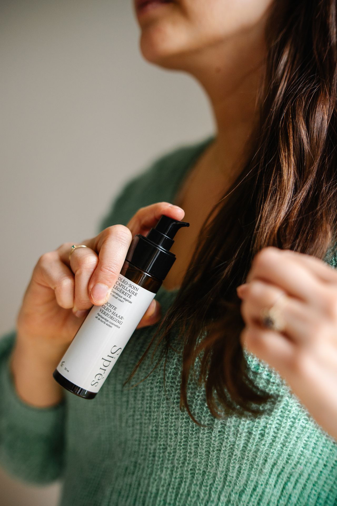 Femme tenant le soin capillaire équilibrant et léger, sebo-régulateur, assainissant et apaisant Siprès.