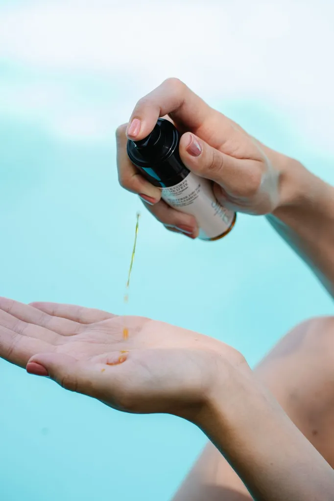 application et coulure huile corps sèche été mains Lou devant piscine.webp